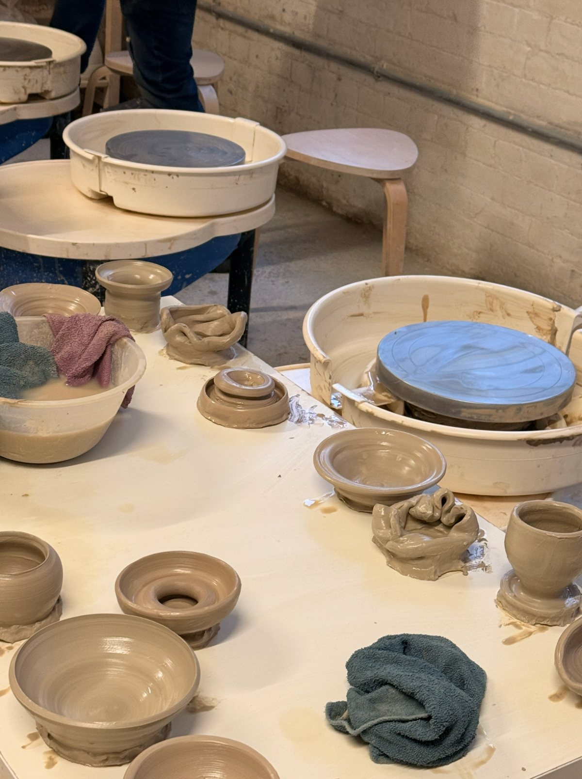 Hands shaping clay on a pottery wheel